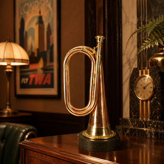 Decorative bugle signal horn with copper-coloured finish and round base presentation at home