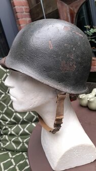 Side view of original McCord M1 infantry helmet with swivel bails and service wear